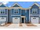 Charming townhome with blue siding, a one-car garage and an inviting black front door at 2032 Summey Ave, Charlotte, NC 28205