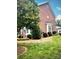 Well-kept brick home featuring lush lawn, mature trees, and landscaped garden beds at 216 Harrison Ln # 4, Locust, NC 28097