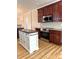 Kitchen features an island, stainless appliances, cherry cabinets, and wood floors at 216 Harrison Ln # 4, Locust, NC 28097