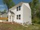 Exterior of a two-story home with white siding, showcasing the side yard and foundation at 2313 Glenwood St, Kannapolis, NC 28083