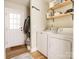 Functional laundry room featuring a washer, dryer, and shelving for organized storage at 2313 Glenwood St, Kannapolis, NC 28083