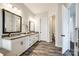 Well-lit bathroom boasts double sinks, wooden-style floors, and white cabinets providing ample storage at 2329 Paddlers Cove Dr, Clover, SC 29710