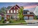 Charming two-story home with red siding, a three-car garage, and a beautifully landscaped front yard at 2329 Paddlers Cove Dr, Clover, SC 29710