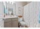 Cozy bathroom featuring neutral cabinets, a framed mirror and a shower with patterned curtains at 2610 Creek Manor Dr, Waxhaw, NC 28173