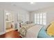 Comfortable bedroom with a bathroom, shutters, and hardwood floors at 2610 Creek Manor Dr, Waxhaw, NC 28173