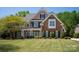 Beautiful brick and stone home with manicured lawn and mature trees provides stately curb appeal at 2610 Creek Manor Dr, Waxhaw, NC 28173