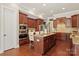 Modern kitchen with stainless steel appliances, wood cabinets, and a granite-topped island with seating at 2610 Creek Manor Dr, Waxhaw, NC 28173
