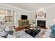 Elegant living room with a fireplace, a large clock, a TV, and comfortable seating at 2610 Creek Manor Dr, Waxhaw, NC 28173
