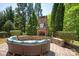 Outdoor stone fireplace with seating area with trees and landscaping at 2610 Creek Manor Dr, Waxhaw, NC 28173