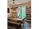 Bright dining room featuring large wooden table, modern lighting, and views of the outdoor foliage at 2656 Lee Lawing Rd, Lincolnton, NC 28092