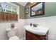 Charming bathroom with pedestal sink, decorative mirror, and a bright window view at 2909 Park Rd, Charlotte, NC 28209