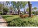 Landscaped front yard with flowers and green grass of a beautiful gray brick home with white picket fence in distance at 2909 Park Rd, Charlotte, NC 28209
