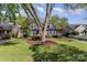 Beautifully landscaped front yard with a mature tree in front of a gray brick home with dormer windows at 2909 Park Rd, Charlotte, NC 28209