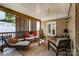 Relaxing covered porch with comfortable seating, wood accents, and a brick wall at 2909 Park Rd, Charlotte, NC 28209
