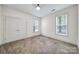Bright bedroom featuring neutral carpet, double door closet, and two windows allowing natural light at 2959 Bellasera Way, Matthews, NC 28105