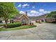 Charming single-story home featuring stone and brick exterior, well-manicured lawn, and mature landscaping at 2959 Bellasera Way, Matthews, NC 28105