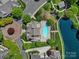 Aerial view features a pristine community pool, surrounded by lounge chairs, landscaping, and a tranquil pond at 2959 Bellasera Way, Matthews, NC 28105