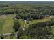 Aerial shot of a secluded property with a large home, detached garage, and surrounded by dense forest at 3677 Antioch Church Rd, Matthews, NC 28104