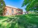 Expansive backyard featuring a brick home, lush lawn, and mature trees at 3677 Antioch Church Rd, Matthews, NC 28104