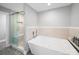 Contemporary bathroom featuring glass enclosed shower and soaking tub with tile surround at 3677 Antioch Church Rd, Matthews, NC 28104