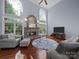 Cozy living room boasts a stone fireplace, soaring ceilings, and large arched windows at 3677 Antioch Church Rd, Matthews, NC 28104
