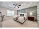 This main bedroom features a tray ceiling, gray accent wall, and is well-lit by a ceiling fan and recessed lighting at 4032 Wild Turkey Ln, Indian Land, SC 29707