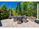 Outdoor dining area with wicker table and chairs beneath an umbrella, surrounded by greenery at 4032 Wild Turkey Ln, Indian Land, SC 29707
