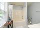 Well-lit bathroom features a tub-shower combo with modern fixtures and a decorative side table at 4133 Carl Parmer Dr, Harrisburg, NC 28075
