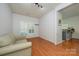 Well-lit bedroom featuring hardwood floors, a neutral sofa, and a view into the kitchen at 4133 Carl Parmer Dr, Harrisburg, NC 28075