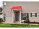 Close-up of front door with red accent roof showing shutters, siding, and manicured lawn at 4133 Carl Parmer Dr, Harrisburg, NC 28075