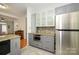 Modern kitchen with stainless steel appliances, gray cabinets, stone countertops, and tile flooring at 4133 Carl Parmer Dr, Harrisburg, NC 28075
