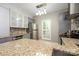 Well-lit kitchen with gray cabinets, stone countertops, stainless steel appliances, and stone tile backsplash at 4133 Carl Parmer Dr, Harrisburg, NC 28075