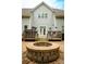 Exterior of home featuring a brick patio with a stone fire pit and access to hot tub at 4205 Green Park Ct, Harrisburg, NC 28075