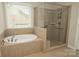 Bathroom showcasing a soaking tub and a separate glass-enclosed shower at 4205 Green Park Ct, Harrisburg, NC 28075