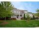Charming two-story home with manicured lawn, gray siding, stone accents and welcoming front porch at 4205 Green Park Ct, Harrisburg, NC 28075