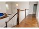 Hallway with wooden floors and banister overlooking staircase with fish decor at 4205 Green Park Ct, Harrisburg, NC 28075