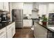 Well-lit kitchen features stainless steel appliances, white cabinets, and granite countertops at 4205 Green Park Ct, Harrisburg, NC 28075