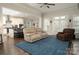 Open-concept living room featuring a blue rug and views into the kitchen area at 4205 Green Park Ct, Harrisburg, NC 28075