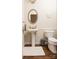 Powder room with pedestal sink, oval mirror, modern fixtures, and hardwood floors at 4205 Green Park Ct, Harrisburg, NC 28075
