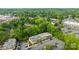 Bird's-eye view of apartment buildings nestled among dense trees, featuring a parking area and serene neighborhood streets at 4754 Hedgemore Dr # O, Charlotte, NC 28209