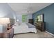 Bedroom with blue accent wall, ceiling fan, and dresser with large mirror at 4754 Hedgemore Dr # O, Charlotte, NC 28209