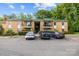 Brick apartment building featuring multiple balconies, a green roof, and ample parking spaces at 4754 Hedgemore Dr # O, Charlotte, NC 28209
