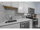 An updated kitchen featuring white cabinets, stainless steel appliances, and modern countertops at 4754 Hedgemore Dr # O, Charlotte, NC 28209