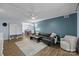 Comfortable living room featuring sleek wood floors, a black leather sofa, and a light-filled dining area at 4754 Hedgemore Dr # O, Charlotte, NC 28209