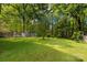 Large backyard featuring mature trees, lush grass and storage sheds at 510 N Jackson Rd, Lancaster, SC 29720