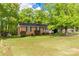 Charming brick home featuring a well-manicured lawn and lush trees creating a serene curb appeal at 510 N Jackson Rd, Lancaster, SC 29720