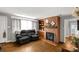 Cozy living room with a brick fireplace, built-in shelving, hardwood floors, and comfortable seating at 510 N Jackson Rd, Lancaster, SC 29720