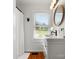 Bright bathroom features modern sink, black faucet, wood floors, and large window for natural light at 512 Secrest Ave, Belmont, NC 28012