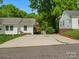 Expansive concrete driveway providing ample parking space, complemented by mature trees and a well-kept lawn at 512 Secrest Ave, Belmont, NC 28012
