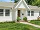 A welcoming porch featuring a classic wooden door, ferns, and freshly cut green lawn at 512 Secrest Ave, Belmont, NC 28012